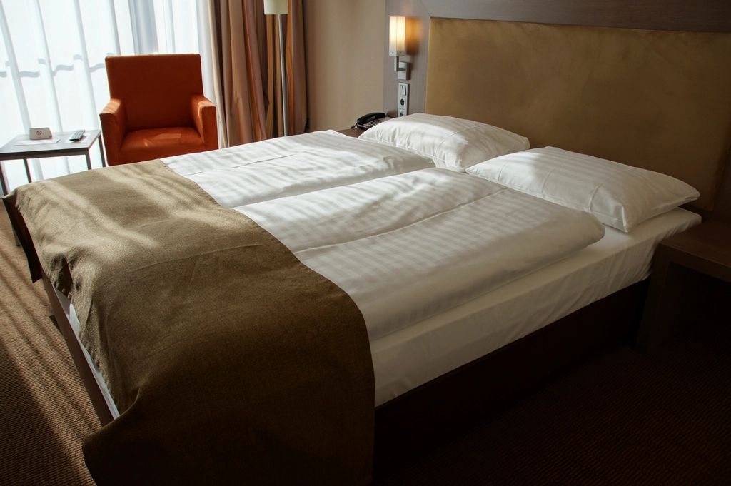 A guest room with a large bed and soft lighting